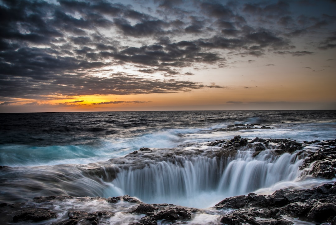 waterfalls under cloudy sky