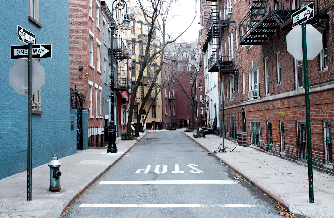 brown concrete street surrounded by buildings,