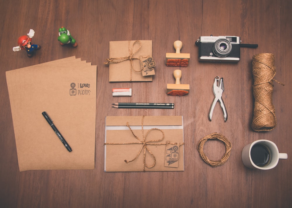 갈색 프린터 용지, 머그잔, 연필 및 카메라의 플랫레이 사진