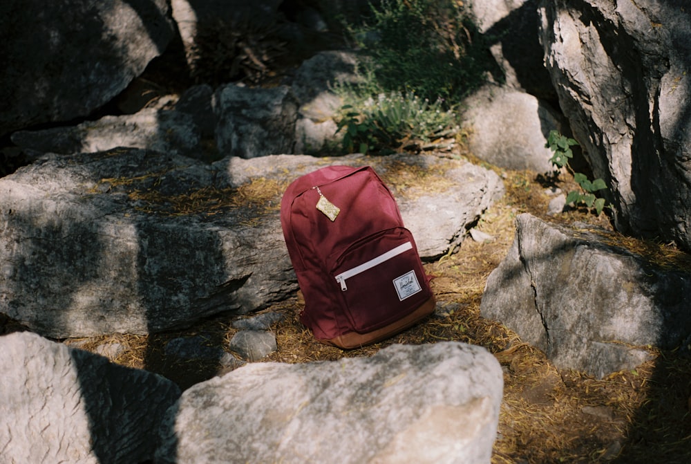 Roter Rucksack auf dem Gipfel des Felsens