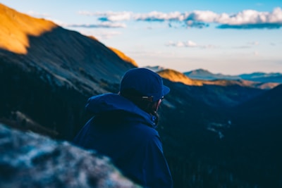 An outdoor enthusiast scanning a rugged mountain landscape with a 247 thermal scanner at twilight.