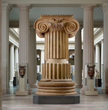 Beige linear icon representing an ancient column for the archaeological museum