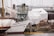 A docked boat labeled 'Freundschaft' is surrounded by various covered structures. The scene includes a mix of maritime equipment, industrial elements, and partially constructed or repaired vessels. The atmosphere is calm and industrious, suggesting a shipyard or harbor setting.