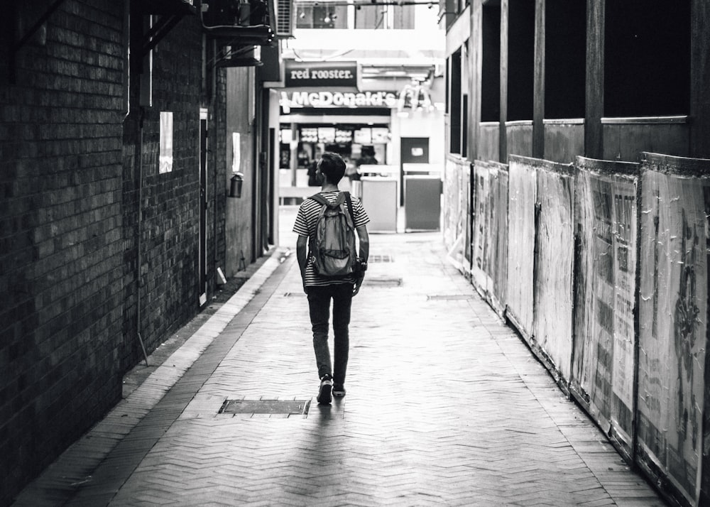 homem caminhando entre edifícios de concreto