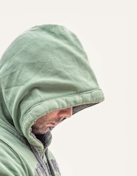 man wearing green hooded jacket with white background
