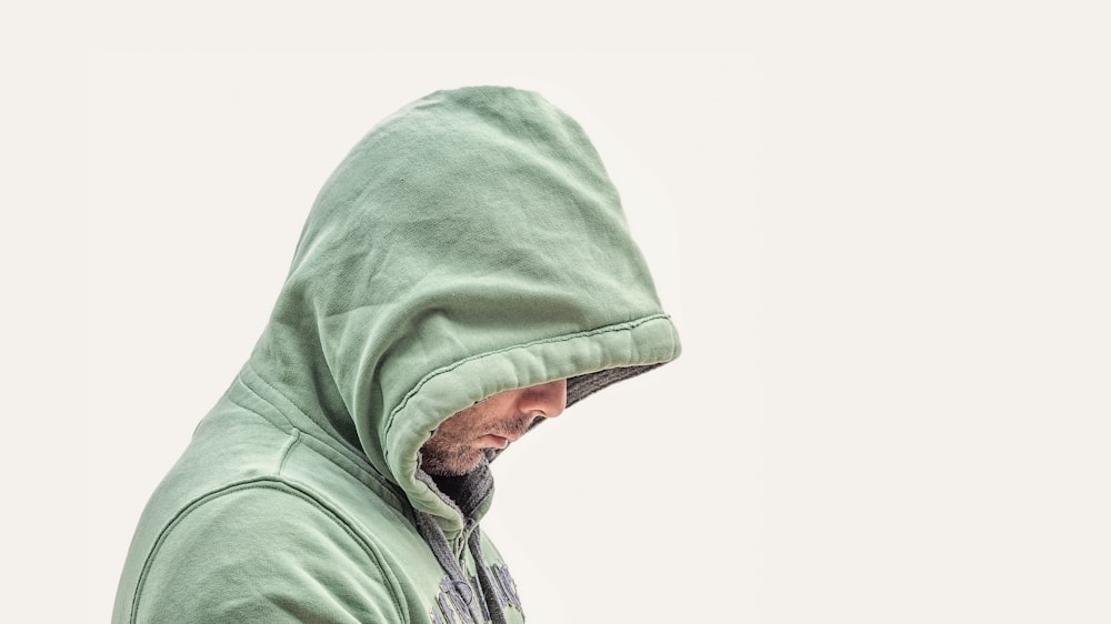 hombre con chaqueta verde con capucha con fondo blanco