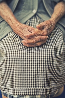 Adult child holding elderly parent's hand