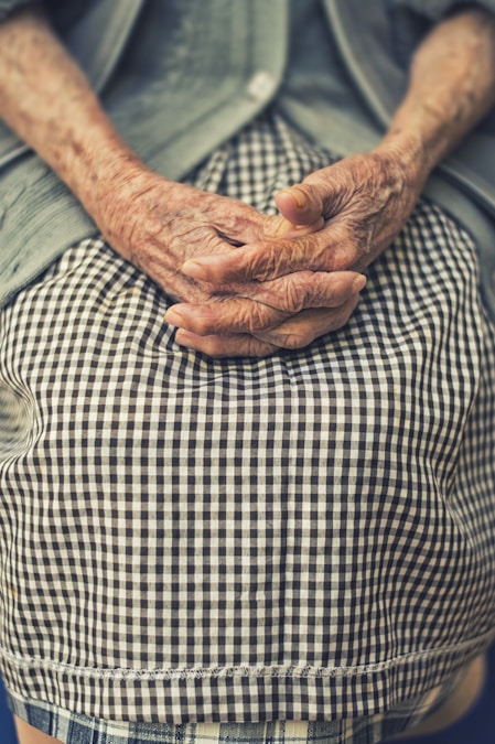 Adult child holding elderly parent's hand
