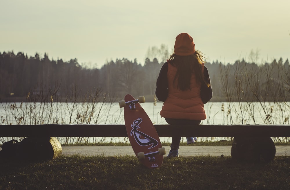 woman sitting on bench with longboard