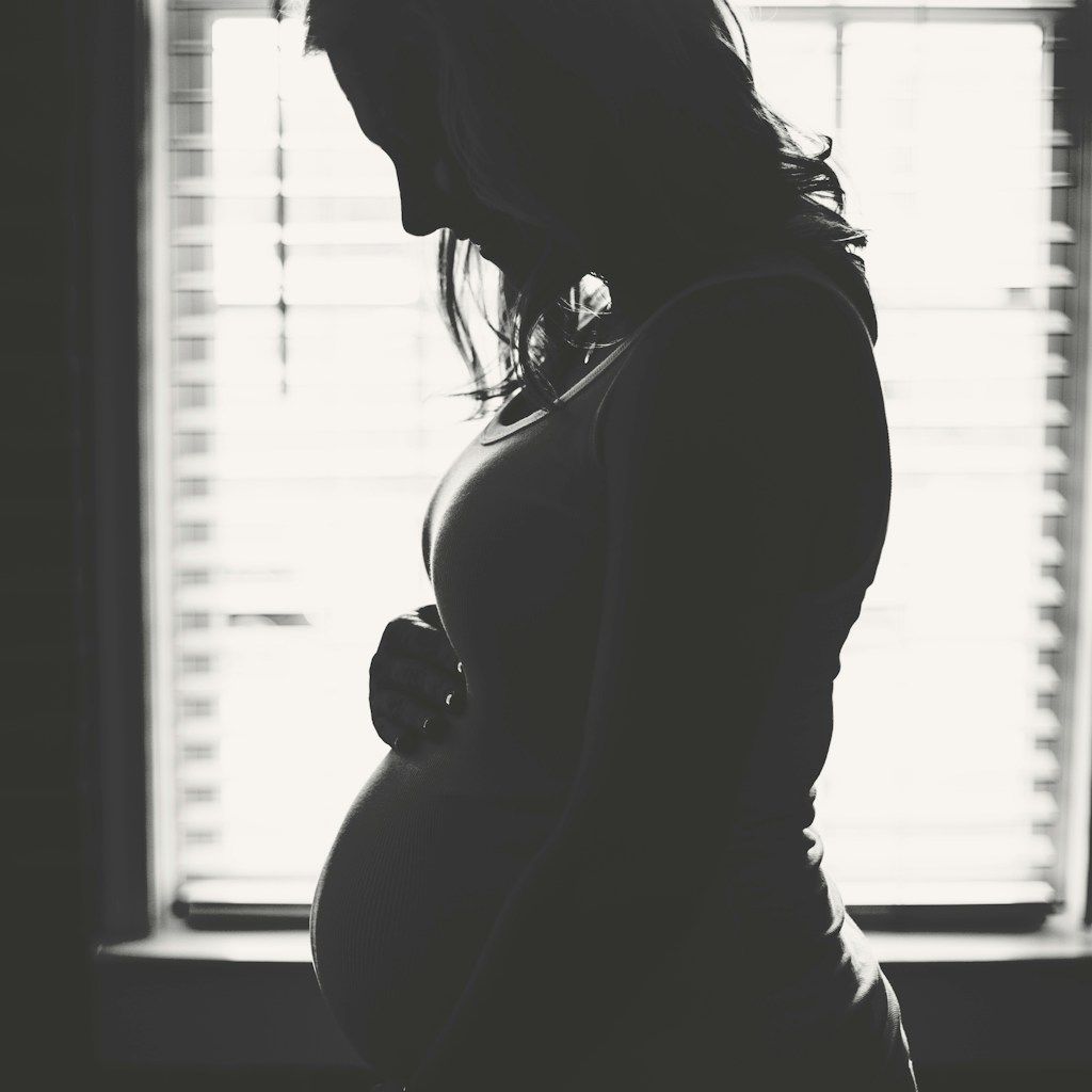 pregnant woman standing inside room during daytime