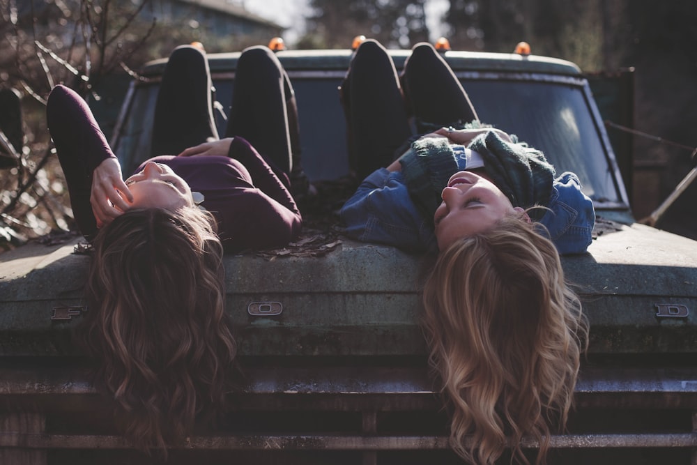 deux femmes allongées sur un véhicule