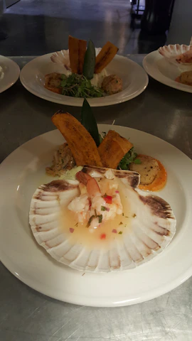 Close-up of a colorful ceviche plate served on the beach with the ocean waves gently rolling in the background.