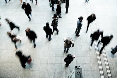 people walking on grey concrete floor during daytime crowd google meet background