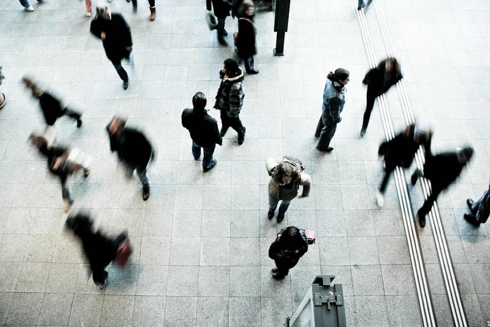 persone che camminano sul pavimento di cemento grigio durante il giorno