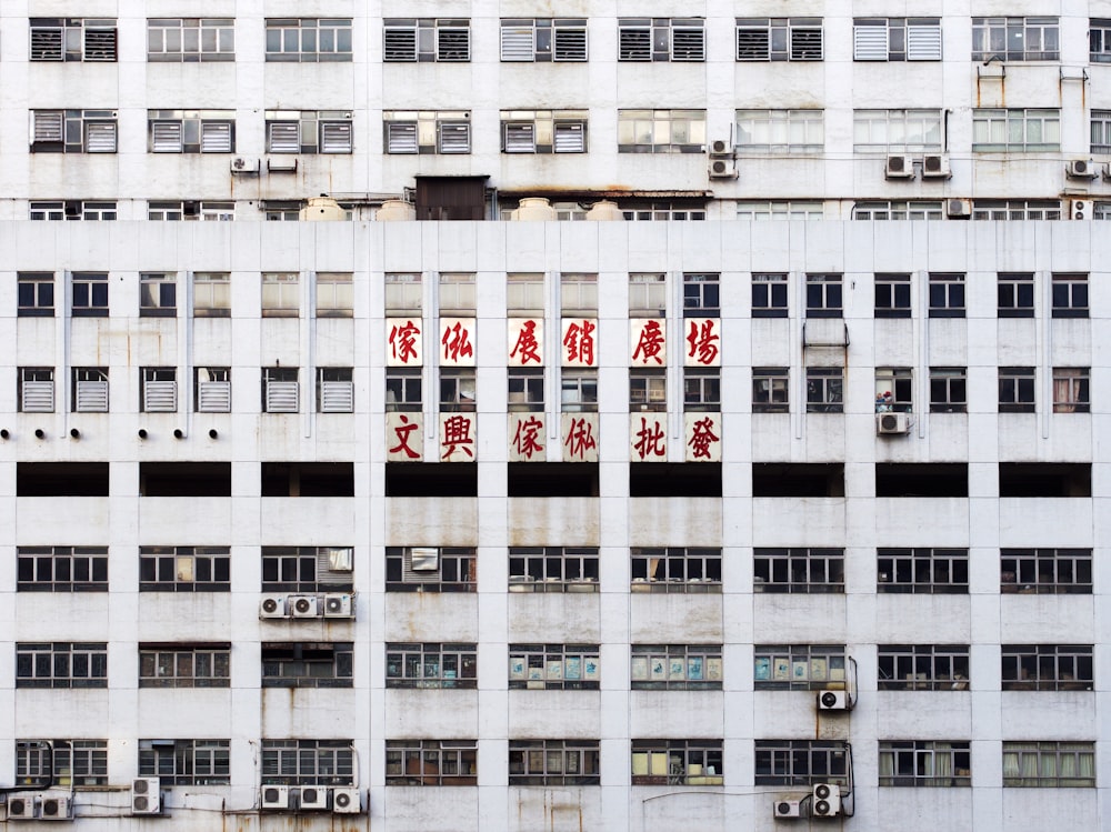 gray multistory building with red Oriental script signage