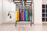 Resistance bands hanging on a wall rack beside a yoga mat and kettlebell
