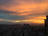 A panoramic view of a colorful city skyline at sunset in paint.