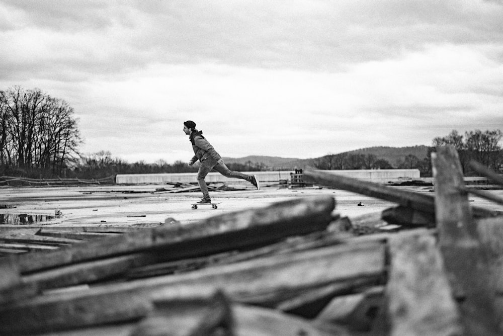 foto em tons de cinza de um homem andando de skate ao ar livre