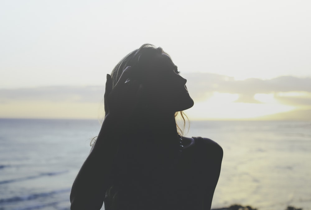 silhouette of woman across sea photo