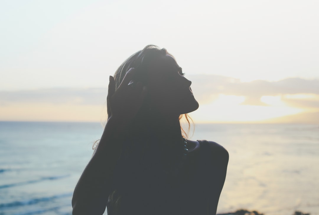 silhouette of woman across sea photo