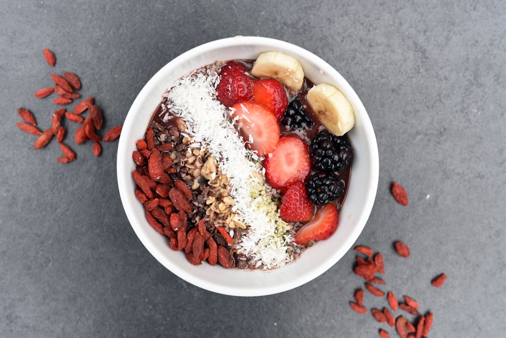 Fresh smoothie bowl with bananas, berries, coconut, and nuts for breakfast