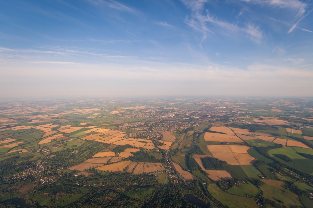 Luftaufnahme von braunen und grünen Feldern unter blauem Himmel bei Tag