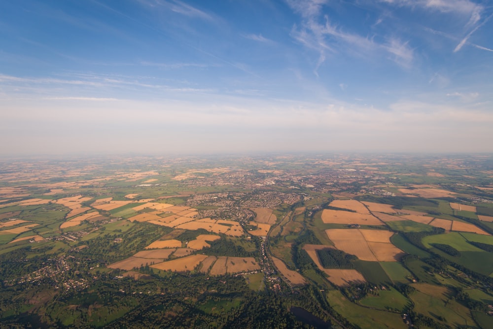 昼間の青空下の茶色と緑の野原の航空写真
