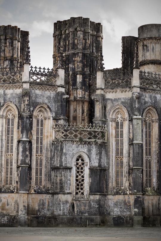 brown and gray concrete building during day in Batalha Monastery Portugal