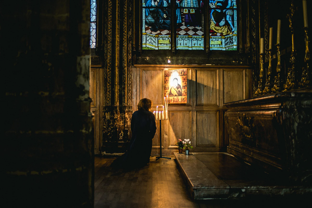 Person praying quietly before a church altar