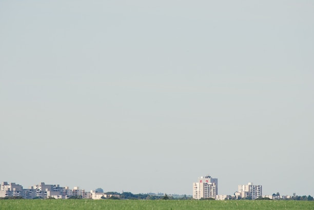 Open land plot with clear sky and distant city view.