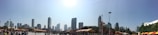 A panoramic view of a city skyline with event banners and crowds.