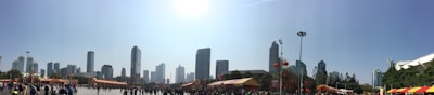 A panoramic view of a city skyline with event banners and crowds.