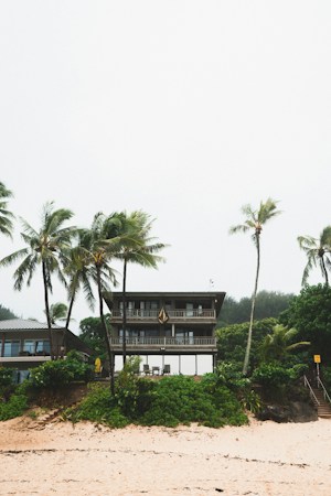 A white single-family home framed by palm trees, the kind of desert-area house an owner might hope to license as a short-term rental in unincorporated Clark County