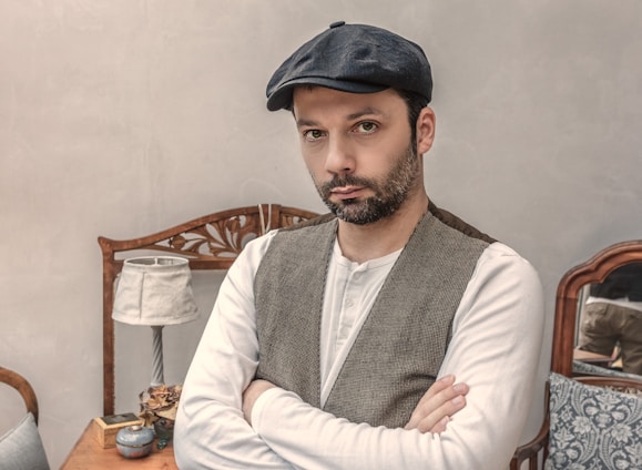 man wearing gray vest near white table lamp