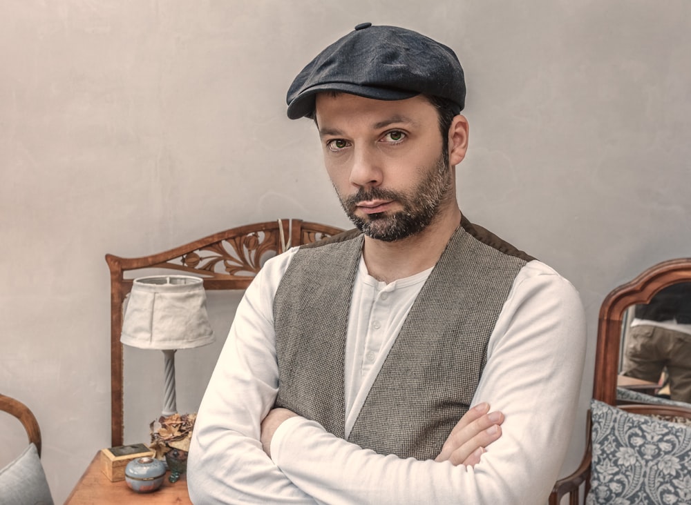 man wearing gray vest near white table lamp