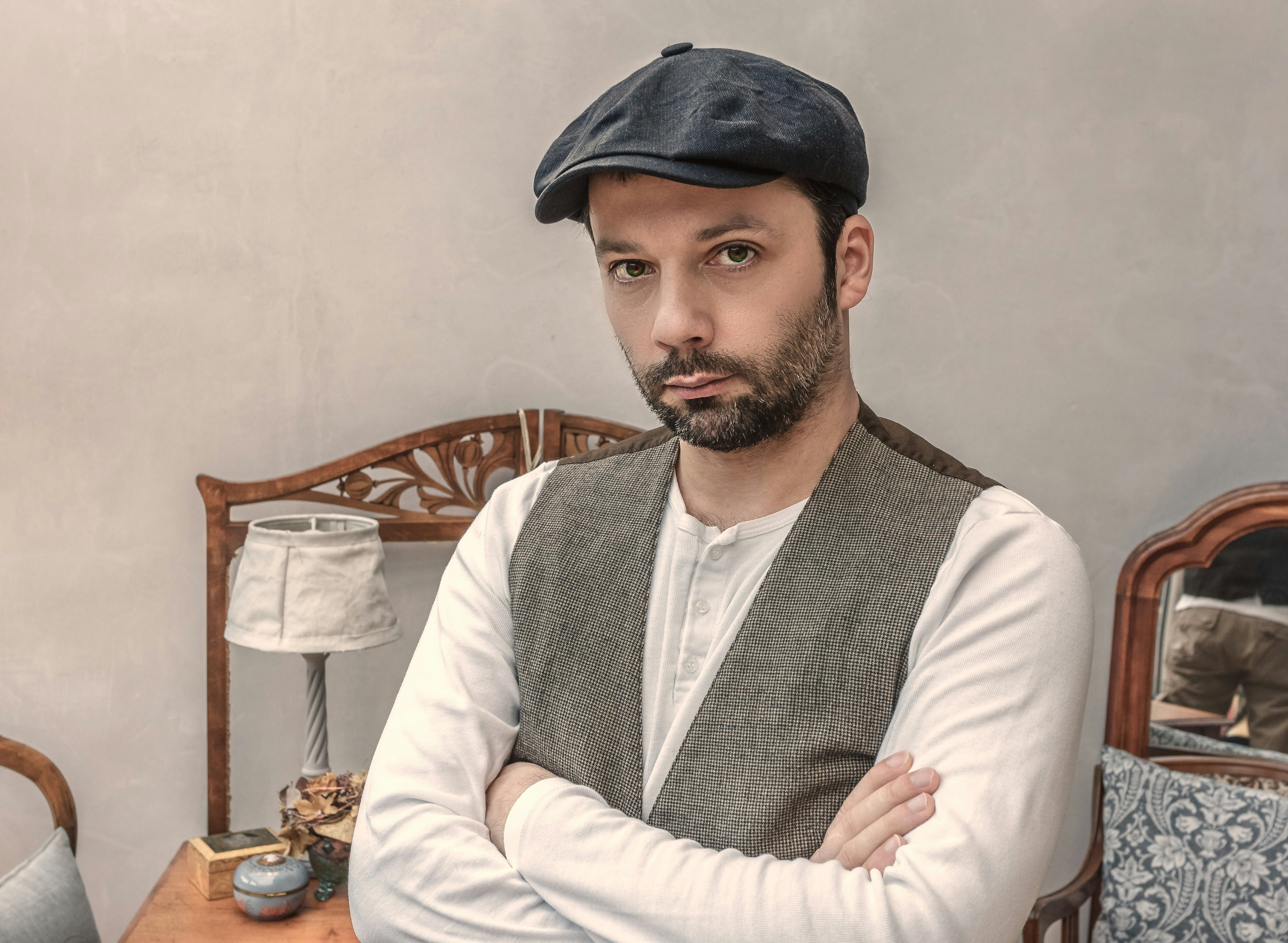 man wearing gray vest near white table lamp