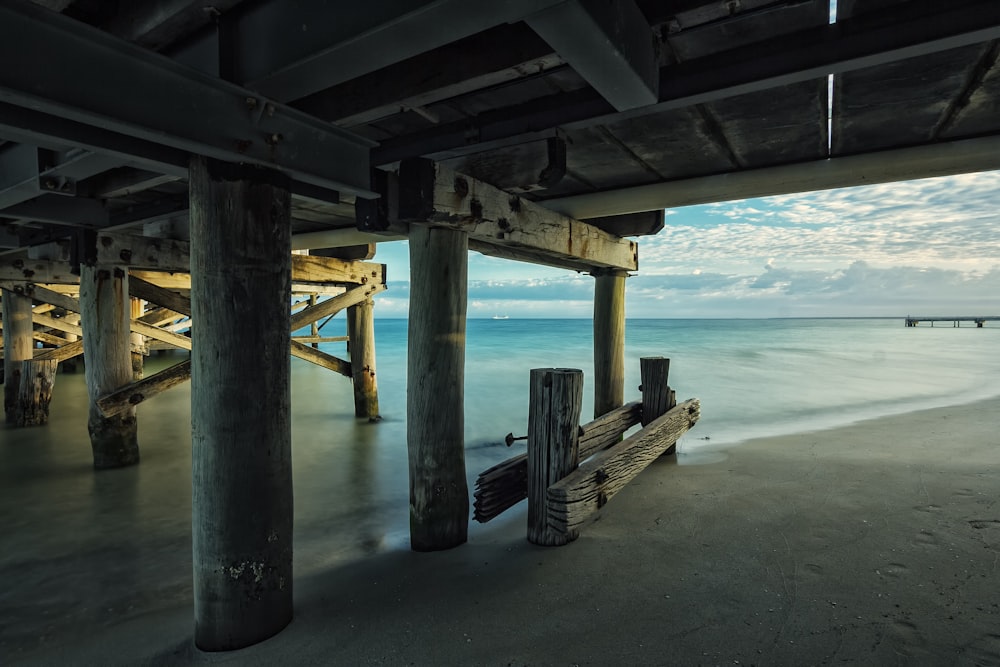 brown wooden footbridge under body of water