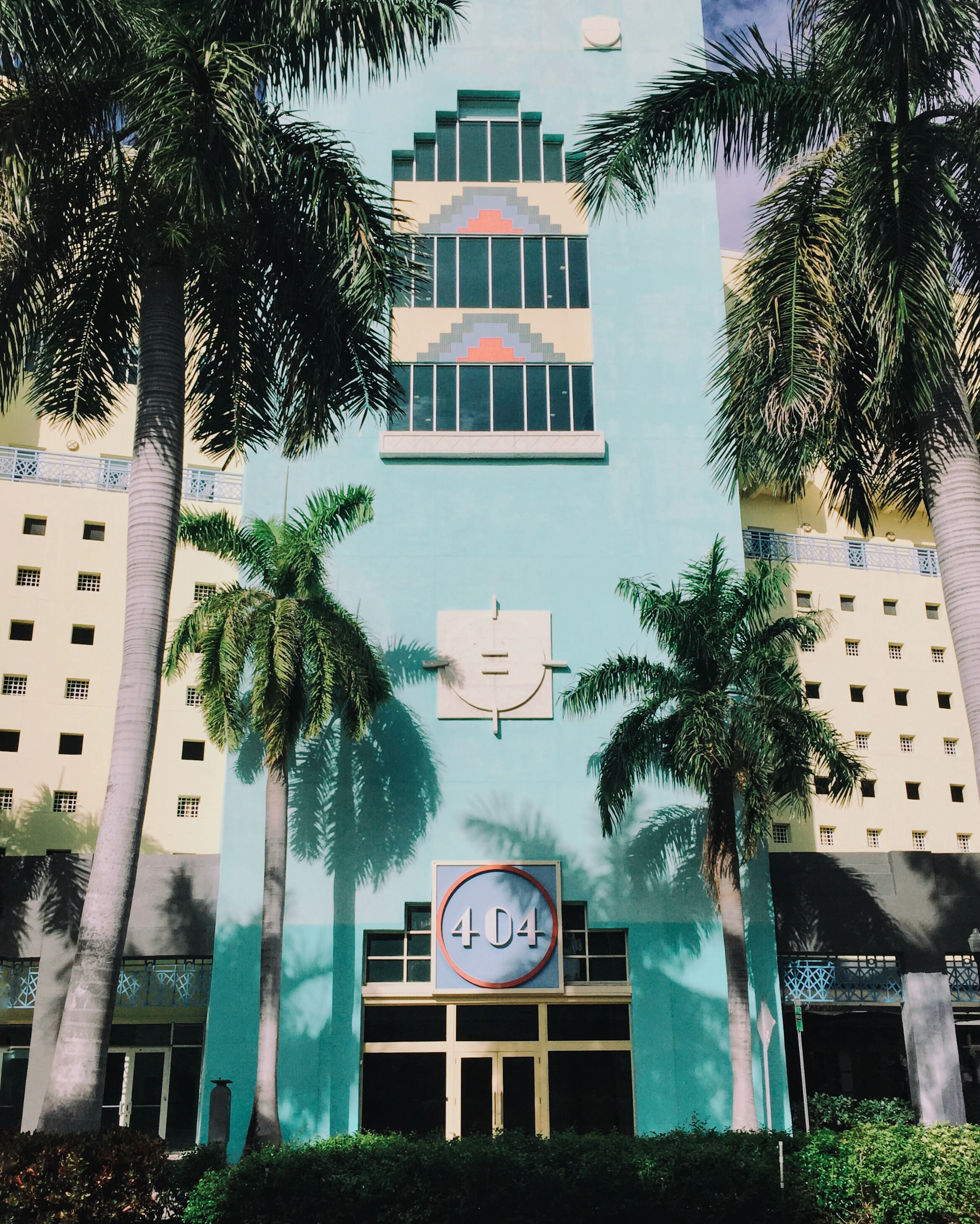 Palm trees beside a pastel building in Miami, seen from directly overhead