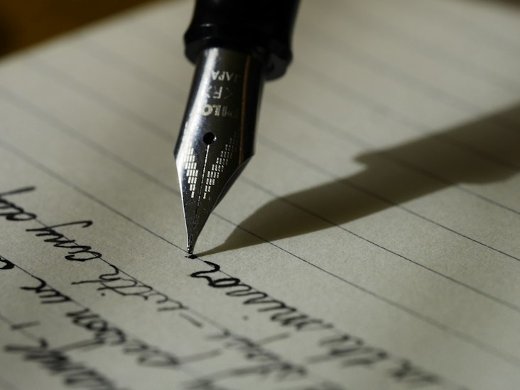 Schreibfeder und Notizbuch