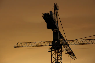 A rugged construction crane silhouetted against a steel-blue sky at dusk, symbolizing enduring American industry.