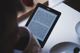 turned on black Amazon Kindle e-book reader