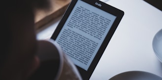 turned on black Amazon Kindle e-book reader