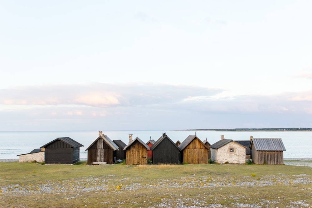 landscape photography of shacks near body of water
