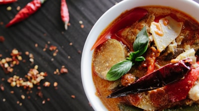 flat-lay photography of vegetable soup on white ceramic cup