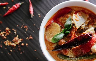 flat-lay photography of vegetable soup on white ceramic cup