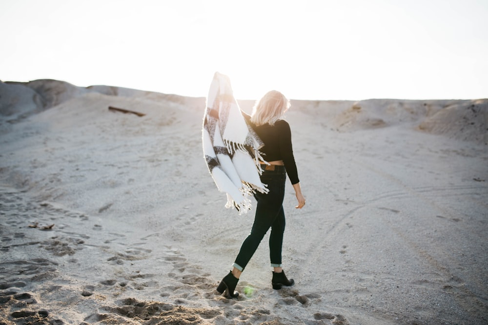 woman standing on gray sand under sunrise