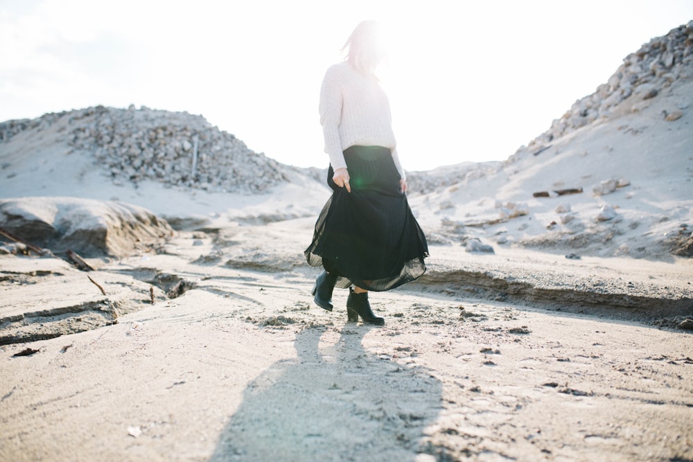 femme en jupe noire marchant sur un sol gris