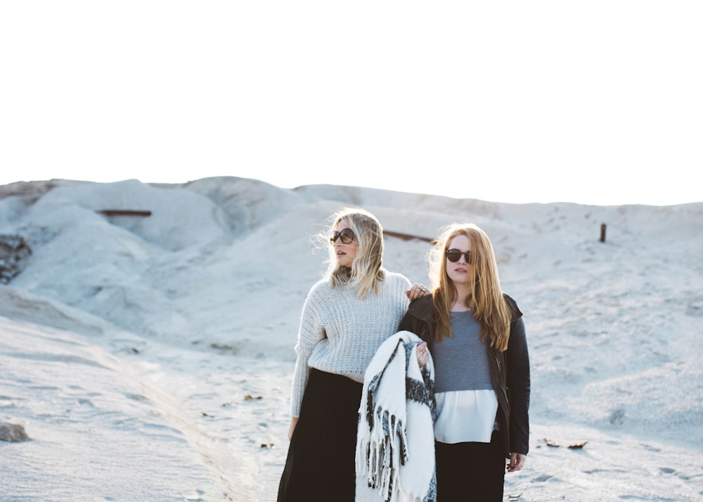 deux femmes debout sur une surface couverte de neige