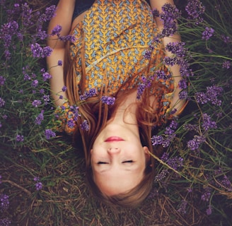 woman in yellow and teal top sleeping beside lavenders