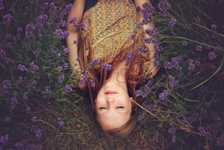 woman in yellow and teal top sleeping beside lavenders